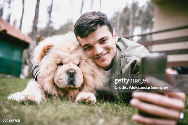 young male taking a selfie with pet chow chow dog - white chow chow stock pictures, royalty-free photos & images