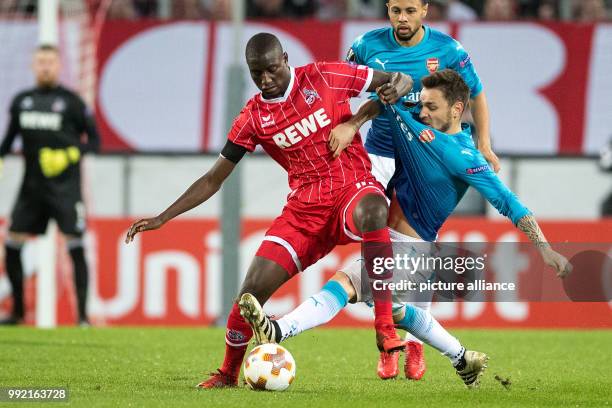 Cologne's Sehrou Guirassy vies for the ball with Arsenal's Mathieu Debuchy during their UEFA Europa League Group H soccer match in Cologne, Germany,...