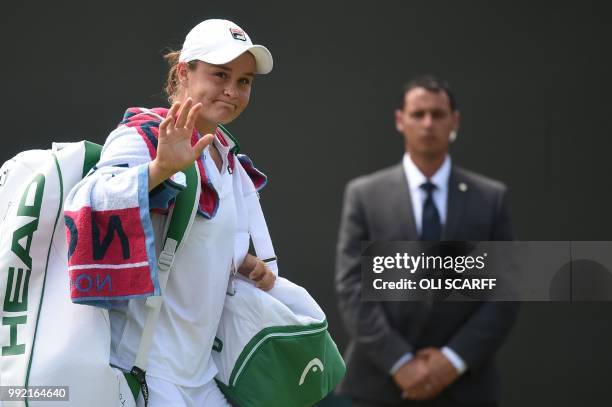 Australia's Ashleigh Barty waves after beating Canada's Eugenie Bouchard 6-4, 7-5 in their women's singles second round match on the fourth day of...