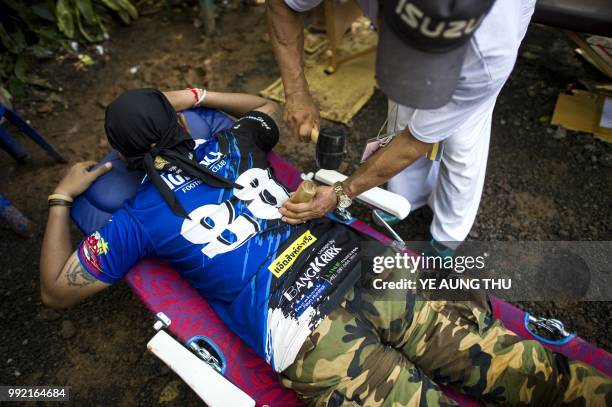 Thai rescue personnel receives a free massage from a volunteer at the Tham Luang cave area as operations continue for 12 boys and their coach trapped...