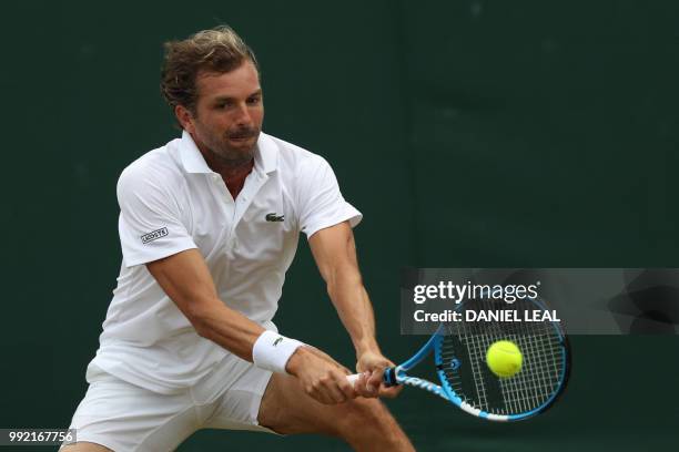 France's Julien Benneteau returns to US player Frances Tiafoe during their men's singles second round match on the fourth day of the 2018 Wimbledon...