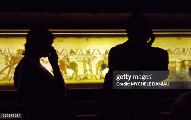 Des visiteurs observent la tapisserie de Bayeux le 27 août 2007 au musée de la tapisserie de la ville. Cette broderie du 11ème siècle est inscrite...