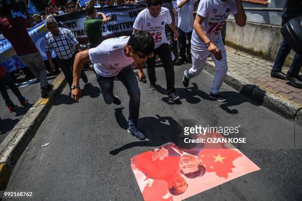 Supporters of the mostly Muslim Uighur minority and Turkish nationalists spit on a poster of Chinese President Xi Jinping and Chinese communist...