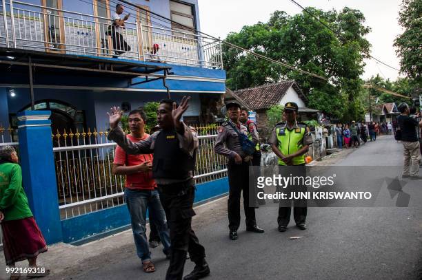 Indonesian police secure the area as they conduct an investigation at a house in the city of Bangil, East Java province on July 5 after an alleged...