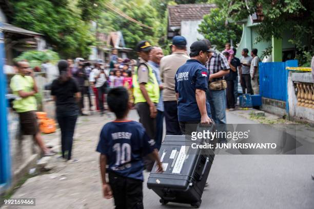 Indonesian police conduct an investigation at a house in the city of Bangil, East Java province on July 5 after an alleged terrorist who managed to...