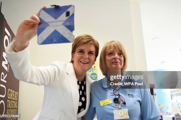 Scotland's First Minister Nicola Sturgeon takes a selfie photograph with a member of staff during a visit to the Royal Hospital for Children to mark...