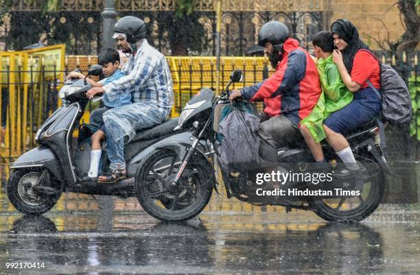 People deal with rain at CSMT, on July 4, 2018 in Mumbai, India. Heavy rains made a comeback in Mumbai causing waterlogging in many parts of the city...