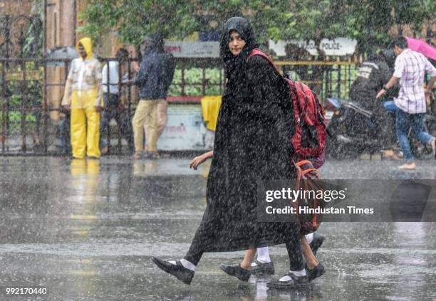 People deal with rain at CSMT, on July 4, 2018 in Mumbai, India. Heavy rains made a comeback in Mumbai causing waterlogging in many parts of the city...