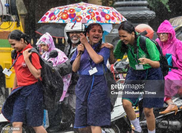 Kids hold umbrella as it rain at CSMT, on July 4, 2018 in Mumbai, India. Heavy rains made a comeback in Mumbai causing waterlogging in many parts of...