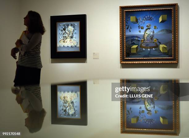 Visitor looks at the paintings "Gala Placidia,1952" and "Galatea in creation, 1954" by artist Salvador Dali during the exhibition entitled "Gala...