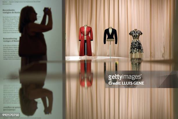 Visitor takes a picture with her smartphone Gala's dresses "Long coat, open at the front from top the botton" , "Night's jacket" and " Blouse and...