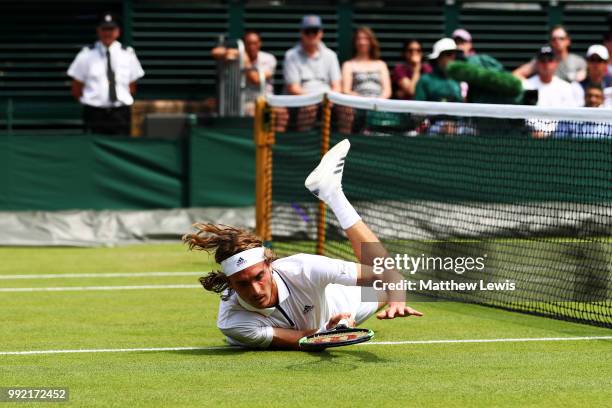 Stefanos Tsitsipas of Greece falls to the court in an attempt to return a shot against Jared Donaldson of the United States during their Men's...