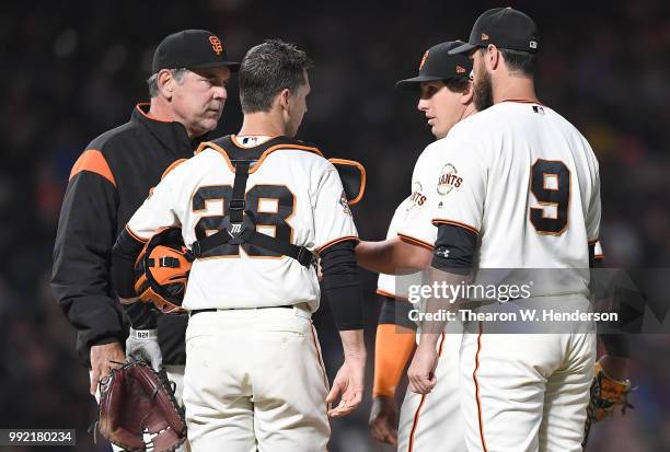 Manager Bruce Bochy of the San Francisco Giants takes the ball from starting pitcher Derek Holland taking Holland out of the game against the...