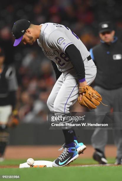 Nolan Arenado of the Colorado Rockies watches the ball hit off of third base for an infield single off the bat of Hunter Pence of the San Francisco...