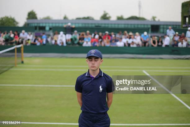 Ballboy waits for play to start on the fourth day of the 2018 Wimbledon Championships at The All England Lawn Tennis Club in Wimbledon, southwest...