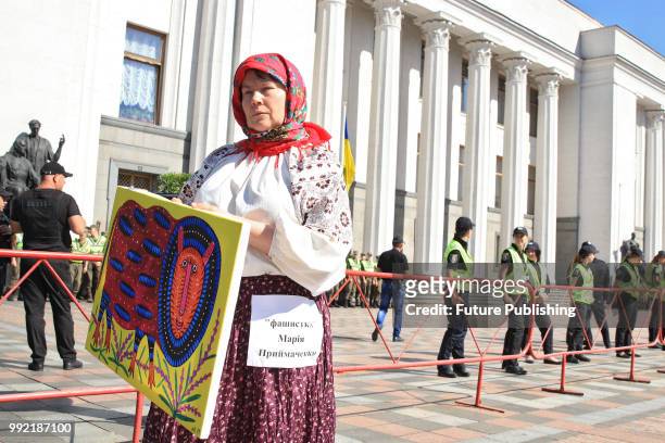 An activist represents Ukrainian folk art painter Maria Pryimachenko during a rally calling to dismiss members of the National Council of Television...