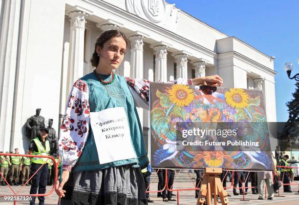 An activist represents Ukrainian painter Kateryna Bilokur during a rally calling to dismiss members of the National Council of Television and Radio...