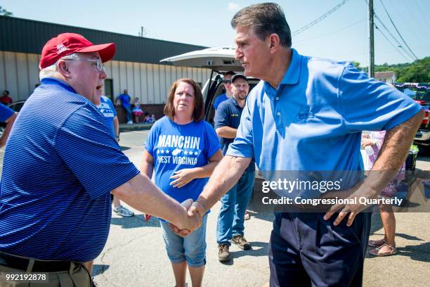 July 4: Sen. Joe Manchin, R-W.Va., shakes hands with Attorney General Patrick Morrisey, who is also running for U.S. Senate, before the start of the...