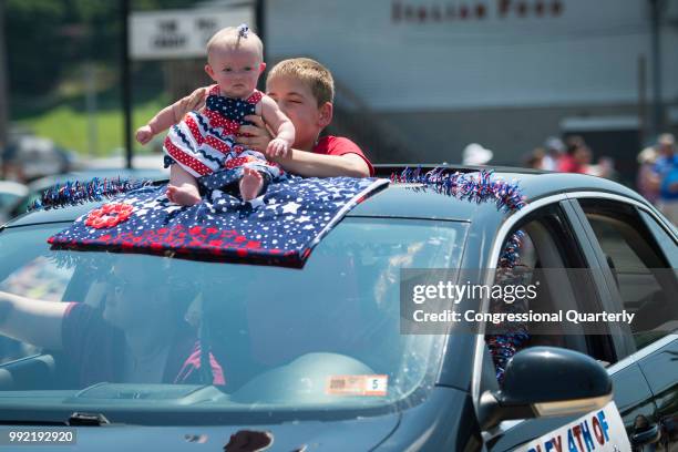 July 4: An infant sits on top of a moving car during the Ripley 4th of July Grand Parade in Ripley, West Virginia Wednesday July 4, 2018.