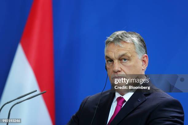 Viktor Orban, Hungary's prime minister, listens via an earpiece during a news conference at the Chancellery in Berlin, Germany, on Thursday July...