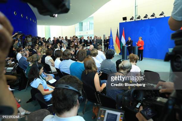 Angela Merkel, Germany's chancellor, right, gestures while speaking at a podium beside Viktor Orban, Hungary's prime minister, during a news...