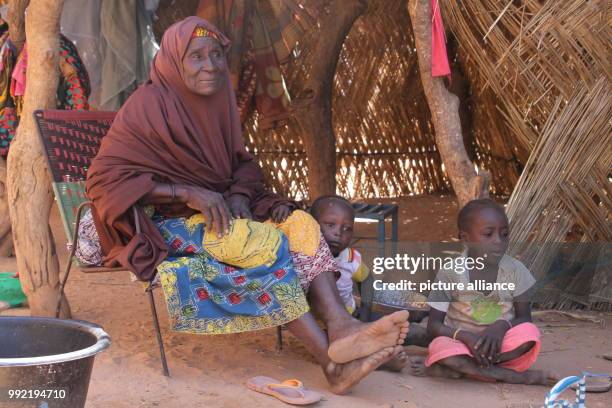 Farmer's wife Hadjo Haruna, who has 13 children and more than 100 grandchildren sits in front of her hut at the village of Koygorou, some 130...