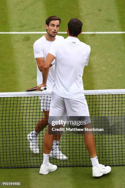 Guido Pella of Argentina shakes hands with Marin Cilic of Croatia after their Men's Singles second round match on day four of the Wimbledon Lawn...