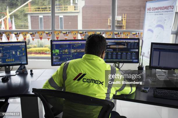 Worker uses computers to monitor the control panels at the Cemex Latam Holdings SA production facility in La Calera, Cundinamarca department,...