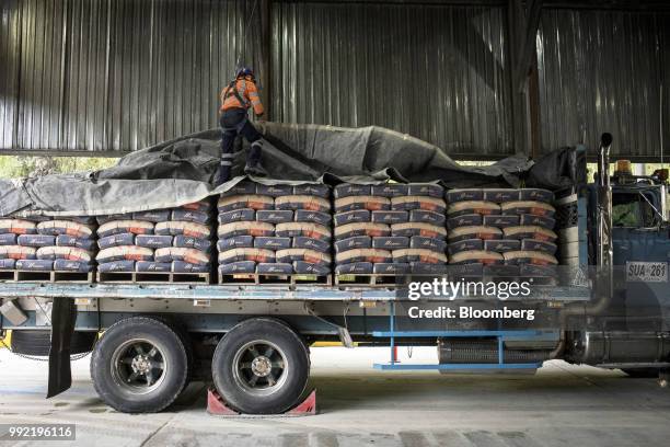 Worker loads cement bags onto a truck at the Cemex Latam Holdings SA production facility in La Calera, Cundinamarca department, Colombia, on Tuesday,...