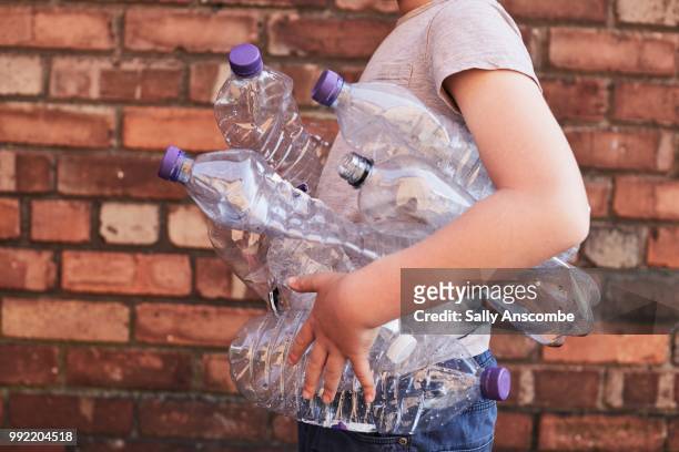 child recycling plastic bottles - sally anscombe stock-fotos und bilder