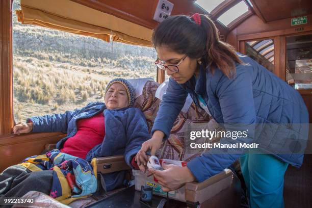 Nurse attends a woman with healt problems because of the altitude during a trip in the world famous Railroad 'Ferrocarril Central Andino' on June 29,...