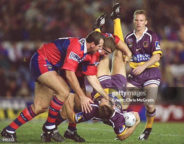 Dane Carlaw of the Broncos is spear tackled by the Knights defence during the round 18 NRL match between the Newcastle Knights and the Brisbane...