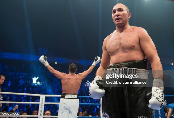Russian Alexander Ustinov walks disappointed across the boxing ring while German Manuel Charr celebrates in the background after the WBA World...