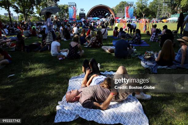 Richard O'Reilly and Brenda Hansen relax while waiting for the Boston Pops Fireworks Spectacular to begin at the Hatch Shell on the Esplanade in...