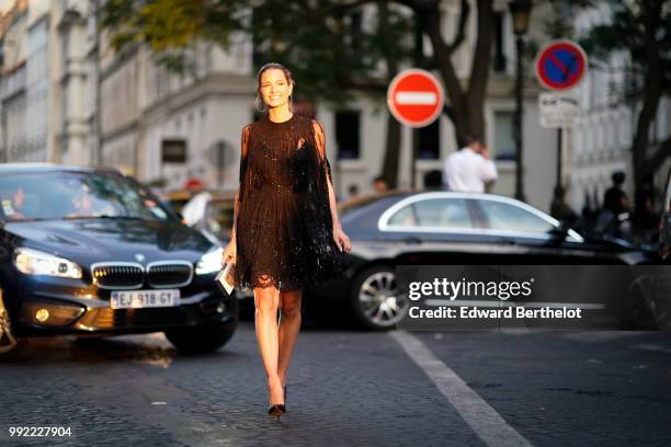 Helena Bordon wears a black lace mesh dress, black heels shoes, outside Valentino, during Paris Fashion Week Haute Couture Fall Winter 2018/2019, on...