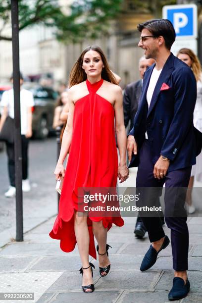 Olivia Palermo wears a red dress ; Johannes Huebl wears a white top, a blazer jacket, blue pants, black shoes, outside Valentino, during Paris...