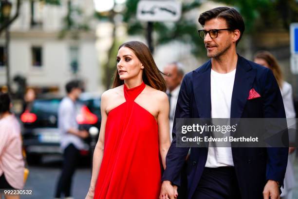 Olivia Palermo wears a red dress ; Johannes Huebl wears a white top, a blazer jacket, blue pants, black shoes, outside Valentino, during Paris...