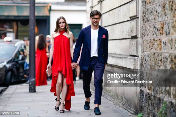 Olivia Palermo wears a red dress ; Johannes Huebl wears a white top, a blazer jacket, blue pants, black shoes, outside Valentino, during Paris...