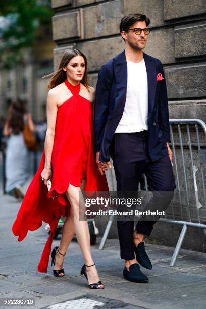 Olivia Palermo wears a red dress ; Johannes Huebl wears a white top, a blazer jacket, blue pants, black shoes, outside Valentino, during Paris...