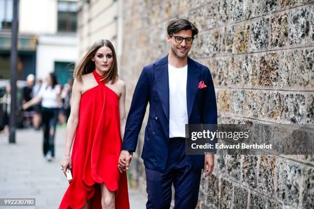 Olivia Palermo wears a red dress ; Johannes Huebl wears a white top, a blazer jacket, blue pants, black shoes, outside Valentino, during Paris...