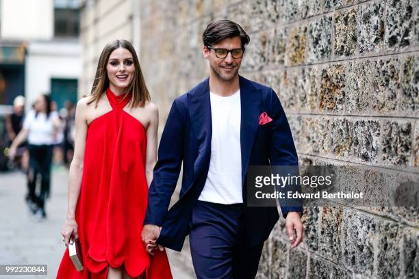 Olivia Palermo wears a red dress ; Johannes Huebl wears a white top, a blazer jacket, blue pants, black shoes, outside Valentino, during Paris...