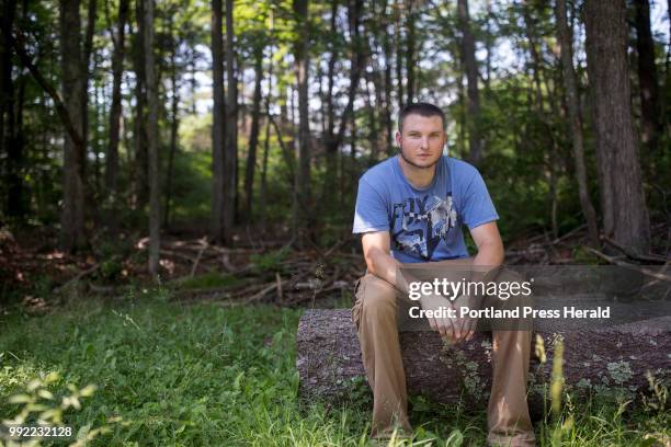 Brandon Radzilowski poses for a portrait in his sister Kristin Bubar's backyard at the edge of the wooded area where a rabid fox came out from on...