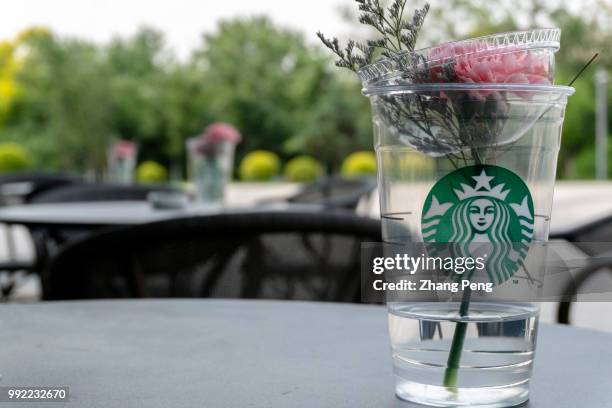 Coffee cup left on the roadside table out of a Starbucks coffee shop. At the global investor conference first held in China on May 26, Starbucks...