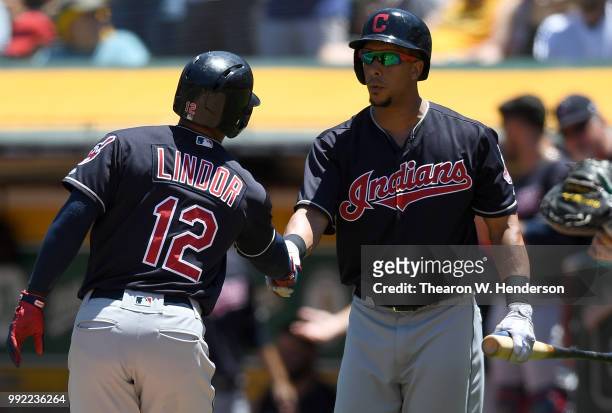 Francisco Lindor of the Cleveland Indians is congratulated by Michael Brantley after Lindor hit a solo home run against the Oakland Athletics in the...