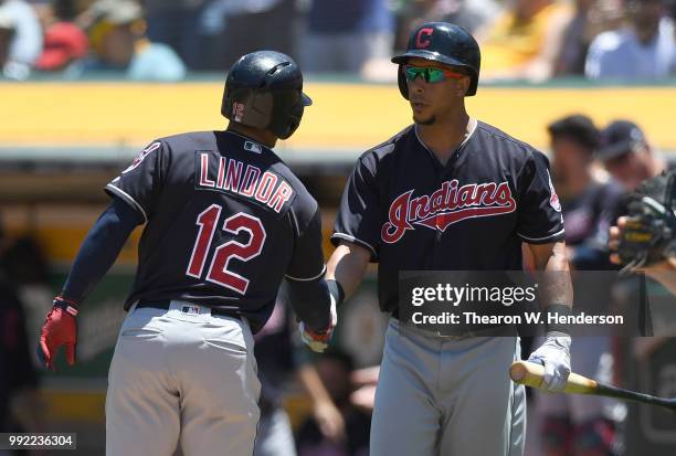 Francisco Lindor of the Cleveland Indians is congratulated by Michael Brantley after Lindor hit a solo home run against the Oakland Athletics in the...