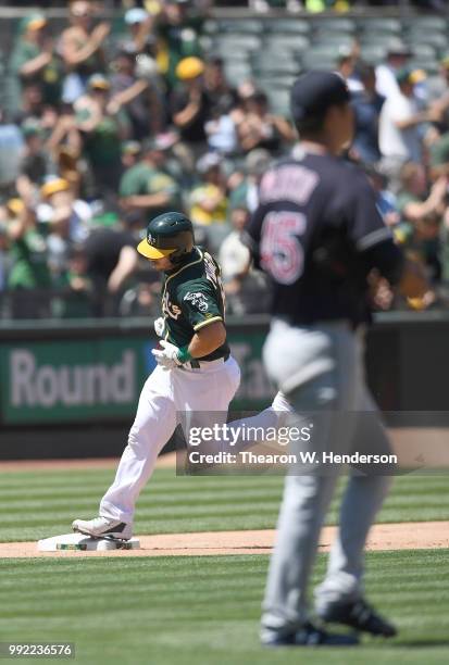 Josh Phegley of the Oakland Athletics trots around the bases after hitting a two-run home run off of Adam Plutko of the Cleveland Indians in the...