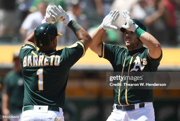 Josh Phegley and Franklin Barreto of the Oakland Athletics celebrates after Phegley hit a two-run home against the Cleveland Indians in the bottom of...