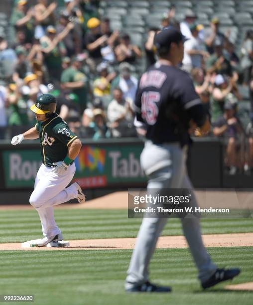 Josh Phegley of the Oakland Athletics trots around the bases after hitting a two-run home run off of Adam Plutko of the Cleveland Indians in the...