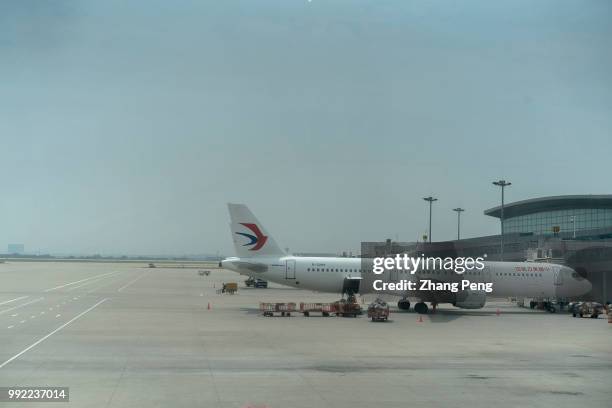 China Eastern Airlines airplane stops on the airport apron, accepting ground service before next taking off. The China Eastern Airlines Co is a...