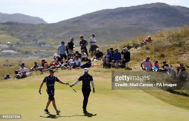 England's Aaron rai is handed a club by his caddy on the fourteenth green during day one of the Dubai Duty Free Irish Open at Ballyliffin Golf Club.